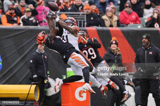 James Proche II the Cleveland Browns while defended by Mike Hilton and Cam Taylor-Britt of the Cincinnati Bengals at Paycor Stadium on January 07,...