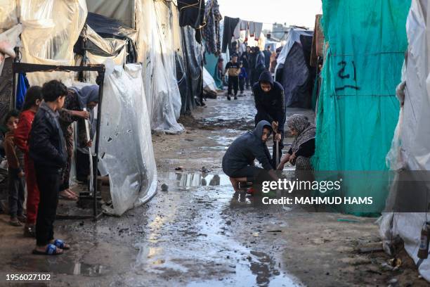 Displaced Palestinians gather amid tents flooded by heavy rain, at a makeshift camp set up by people who fled the ongoing battles between Israel and...