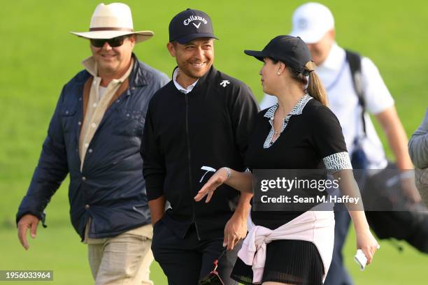Xander Schauffele shaers a laugh with Jasmine Corona near the 18th green of the South Course during the Pro-Am round of the Farmers Insurance Open at...