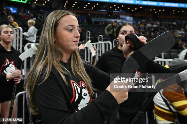 Molly Griffin of the Northeastern Huskies tapes her stick before the 2024 Beanpot Tournament Championship game against the Boston University Terriers...