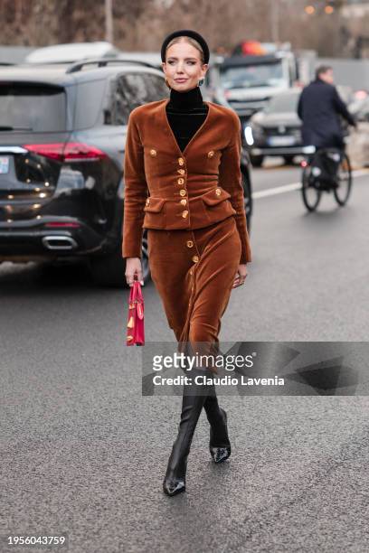 Leonie Hanne wears brown velvet blazer with matching midi skirt, black turtleneck top, black boots, red Schiaparelli bag, outside Schiaparelli,...