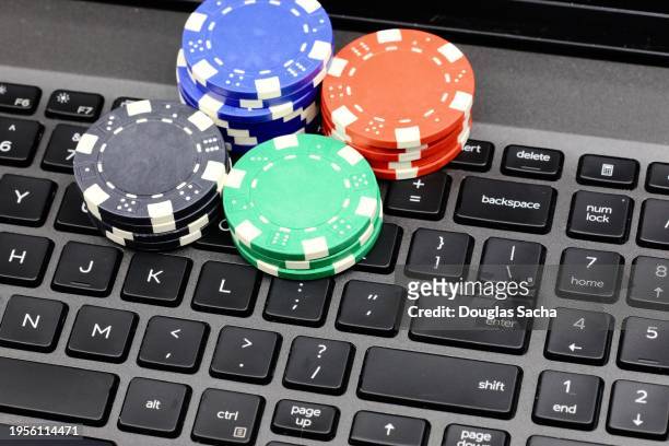 poker chip currency on the computer keyboard - world series of poker stock pictures, royalty-free photos & images