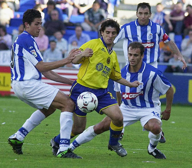Victor of Villareal is challenged by Diego Camacho and Pernia of Recreativo during the La Liga match between Recreativo de Huelva and Villareal at...