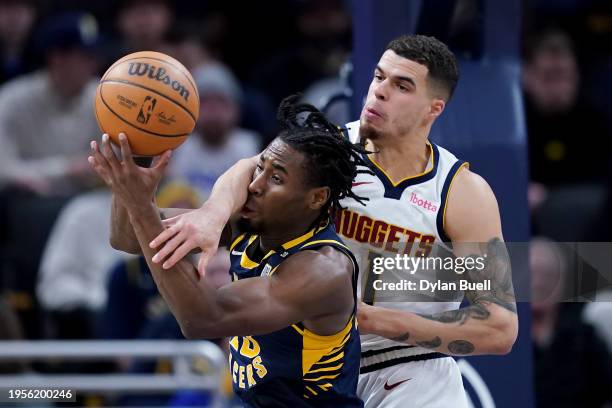 Aaron Nesmith of the Indiana Pacers and Michael Porter Jr. #1 of the Denver Nuggets battle for a rebound in the first quarter at Gainbridge...