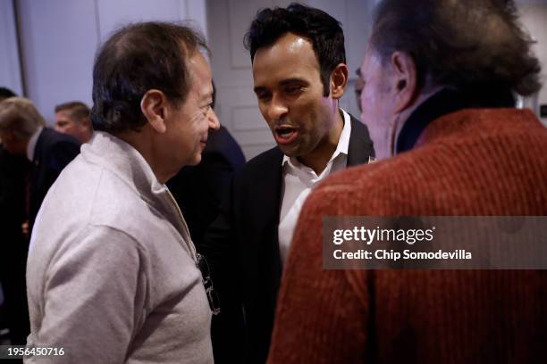 Former Republican presidential candidate Vivek Ramaswamy talks with billionaires John Paulson and Steve Wynn at the conclusion of a primary victory...