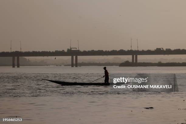 Man is seen in a pirogue on the Niger River in Bamako on January 26, 2024