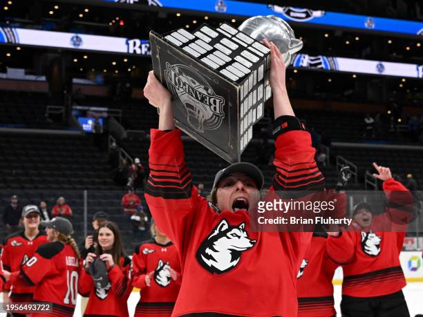 Skylar Irving of the Northeastern Huskies holds up the 2024 Women's Beanpot Tournament Championship trophy after scoring the game-winning goal...