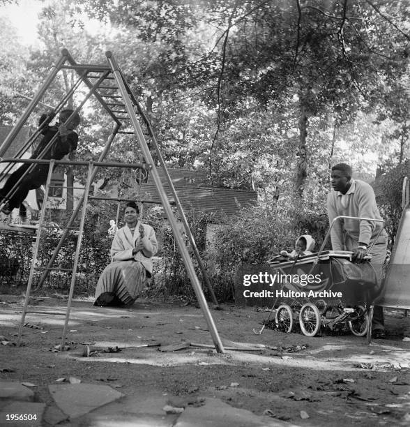 American baseball player Jackie Robinson , his wife Rachel, and infant daughter Sharon watch son Jackie Jr. Play in the backyard of their home in...