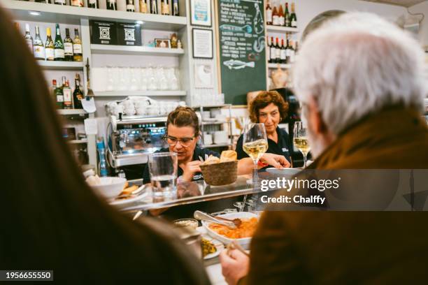 locals enjoying pintxos( pincho or tapas) in san sebastián,basque,spain - empregado de mesa imagens e fotografias de stock
