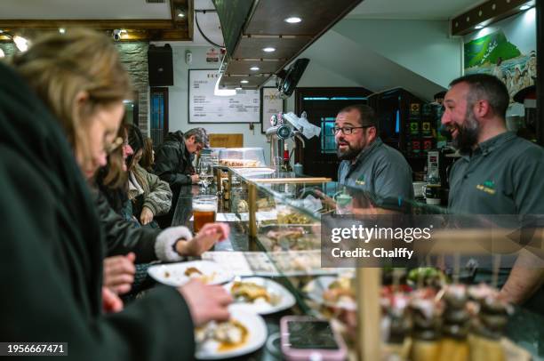 locals enjoying pintxos( pincho or tapas) in san sebastián,basque,spain - são sebastião espanha imagens e fotografias de stock