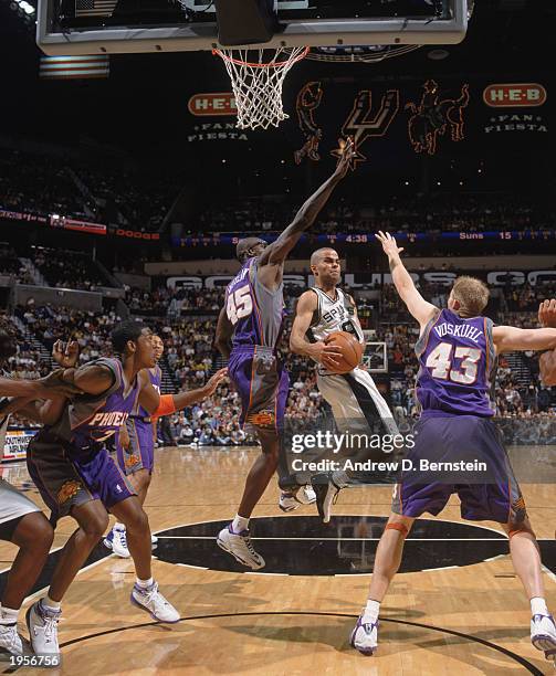 Tony Parker of the San Antonio Spurs goes in for the shot against Bo Outlaw and Jake Voskuhl of the Phoenix Suns during Game Two of the Western...