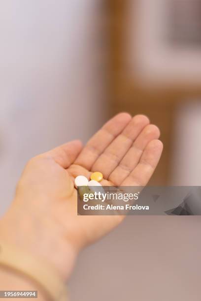 vitamins and pills on the palm close-up - ibuprofen stock pictures, royalty-free photos & images