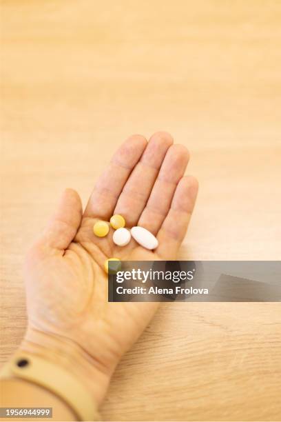 vitamins and pills on the palm close-up - ibuprofen stock pictures, royalty-free photos & images