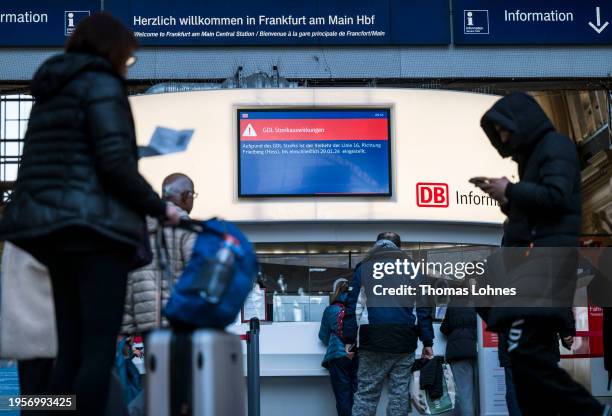 Travelers stand in front of an information booth in the main train station during a nationwide strike by the GDL union of locomotive drivers and rail...