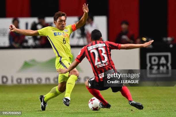 Toshihiro Aoyama of Sanfrecce Hiroshima and Diego Macedo of Consadole Sapporo compete for the ball during the J.League J1 match between Hokkaido...