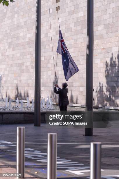 National Galley employee raises the Australian flag that had been lowered by an unknown person before the annual Invasion Day protest. The Indigenous...