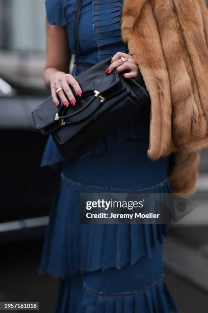 Anna Stukkert seen wearing gold necklace, Marina Fedan blue denim jeans pleated long dress, brown fake fur pilot jacket, black leather handbag,...