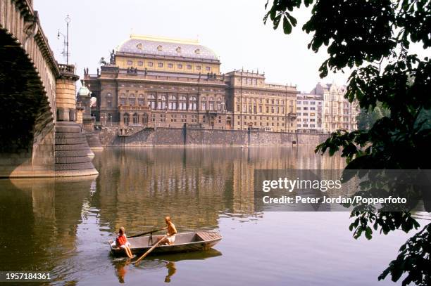 Rowing boat passes under a bridge over the Vltava River in the city of Prague, capital of Czechoslovakia on 19th August 1989.