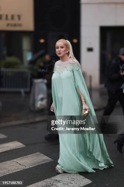 Palina Kozyrava seen wearing Dior silver diamond earrings, Rami Al Ali pastel green embroidered couture cape pleated long dress, Moschino gold...