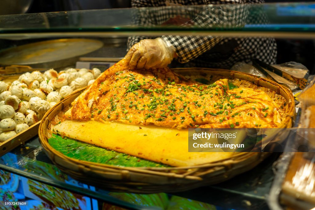 Preparing sacallion pancake at a market stall