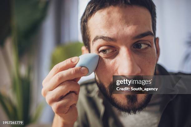 man applying cream for dark circles under eyes - man eye cream stock pictures, royalty-free photos & images