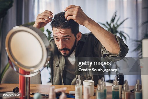 Man styling His Hair at home and putting hair spray Man styling His Hair at home and putting hair spray