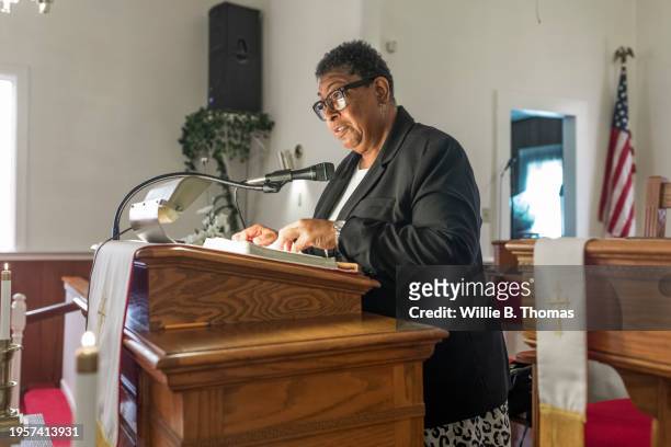 engaged preacher reading scripture at podium - pulpit stock pictures, royalty-free photos & images