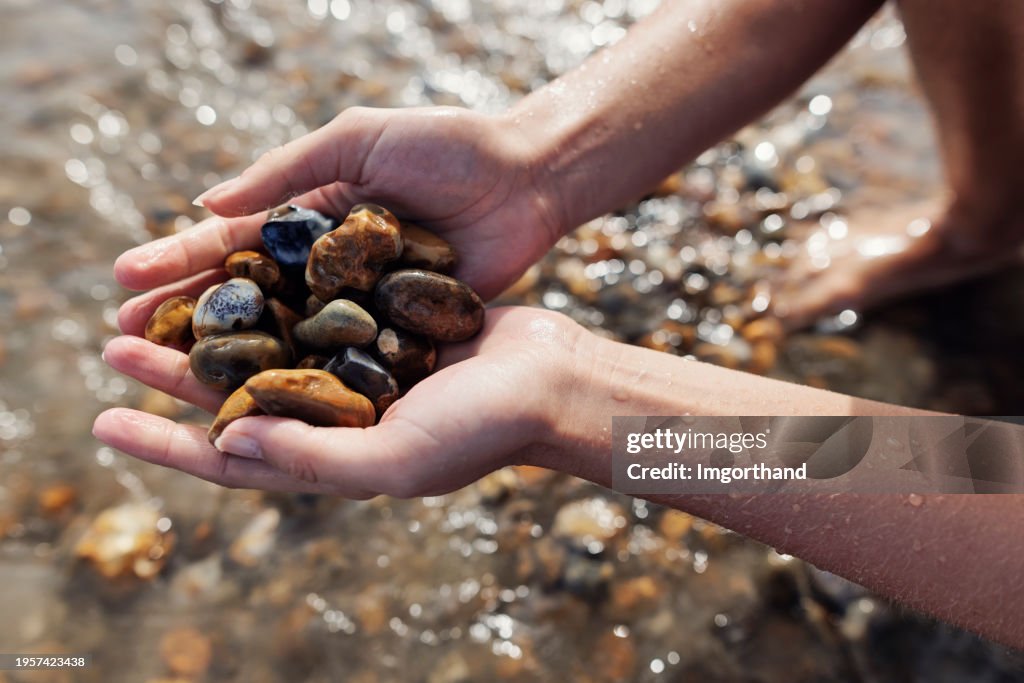 Closeup of teenage girl playing with beautiful stones at a Jurrasic Coast beach, Dorset, United Kingdom