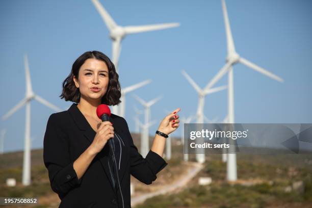 tv news reporter woman making reportage about a renewable energy - film crew interview stock pictures, royalty-free photos & images