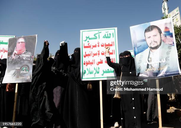 Yemeni female protestors hold placards depicting Houthi group leader Abdul-Malik Badreddin al-Houthi, the Houthi group emblems and shout anti-US, UK,...