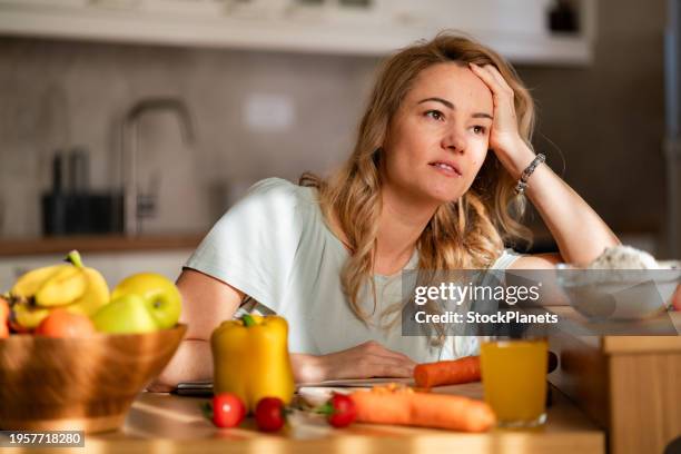 a tired woman is trying to prepare lunch while sitting in the kitchen - misstag bildbanksfoton och bilder