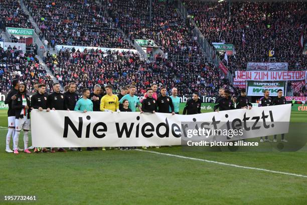 January 2024, Bavaria, Augsburg: Soccer: Bundesliga, FC Augsburg - Bayern Munich, matchday 19 in the WWK Arena, the players of both teams stand...