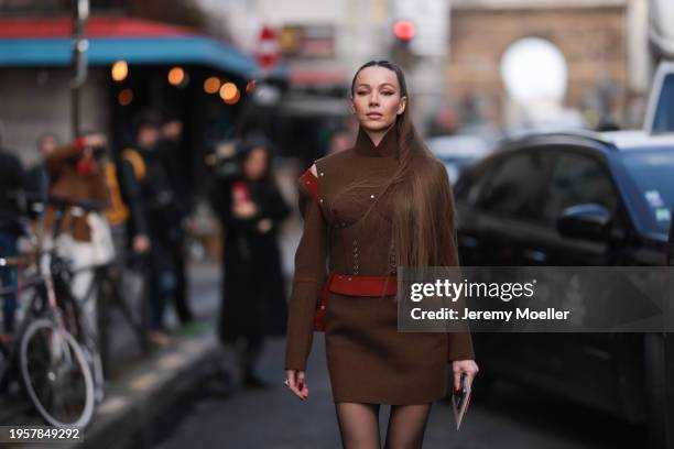 Jurga Fulti seen wearing Vintage 2013 Jean Paul Gaultier brown suit two-piece / top and skirt with red details, black tights, diamond ring and Jean...