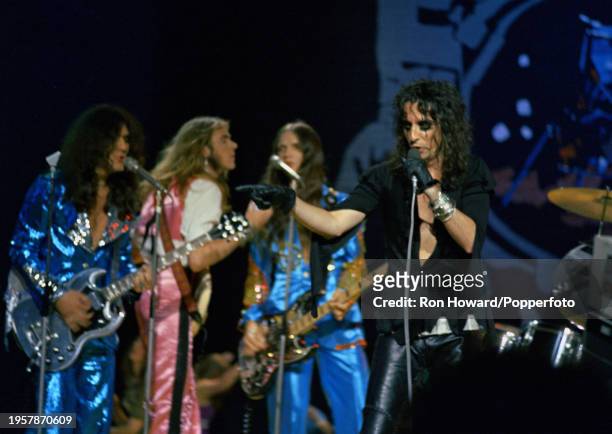 American singer Alice Cooper performs with the rock band Alice Cooper on the set of a pop music television show in London in 1972. Members of the...