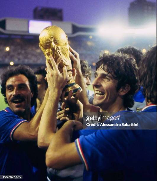 Paolo Rossi and Franco Causio of Italy celebrate with the trophy after winnig the Final FIFA Word Cup Spain 1982 match between Italy and Germany at...