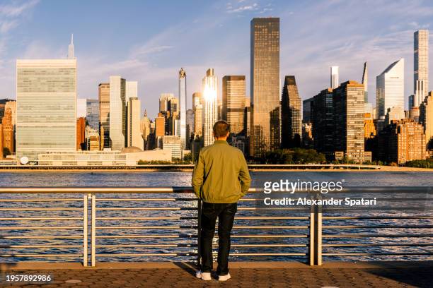 man looking at new york city skyline at sunrise, ny, usa - east river stock pictures, royalty-free photos & images