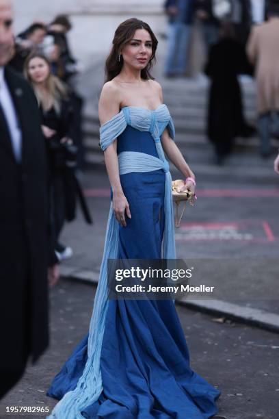 Myrna Al Haddad seen wearing silver diamond earrings, blue / light blue off-shoulder couture long dress and Celine gold leather pattern bag, before...