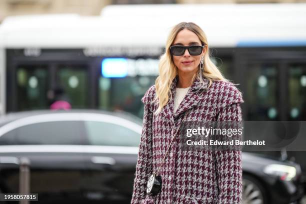 Candela Novembre wears sunglasses, earrings, a white t-shirt, a purple and white houndstooth pattern printed long coat with pockets, a Chanel...