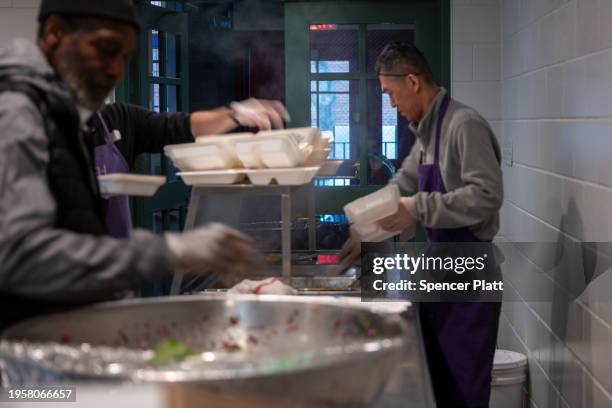 Volunteers prepare meals for a community composed of mostly newly arrived migrants at Trinity Services and Food For the Homeless, across from...
