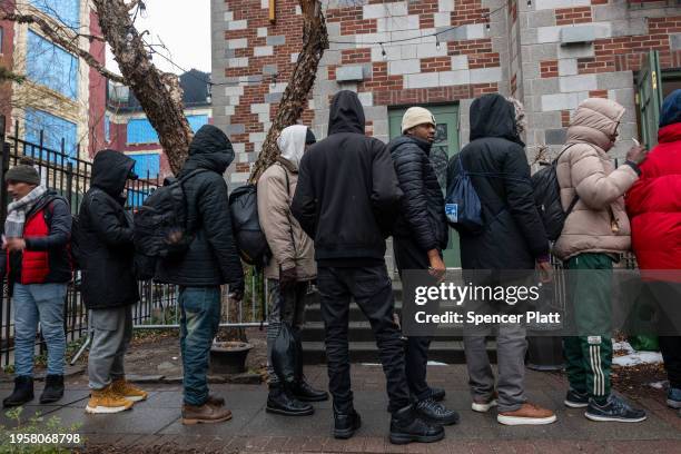 People, mostly newly arrived migrants, receive an afternoon meal from Trinity Services and Food For the Homeless, across from Tompkins Square Park on...