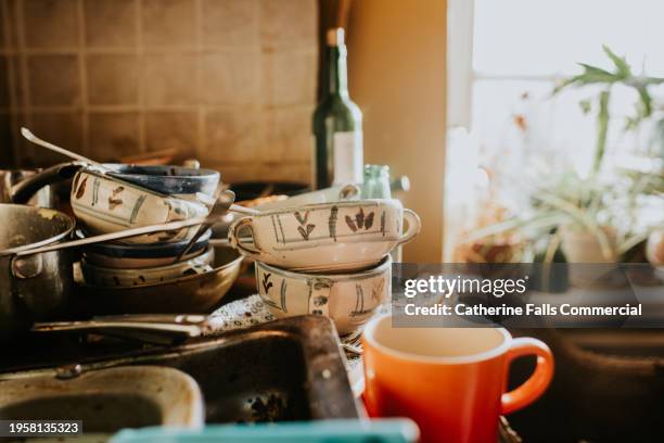 a pile of dirty dishes sit on a countertop in a kitchen - scourer stock pictures, royalty-free photos & images