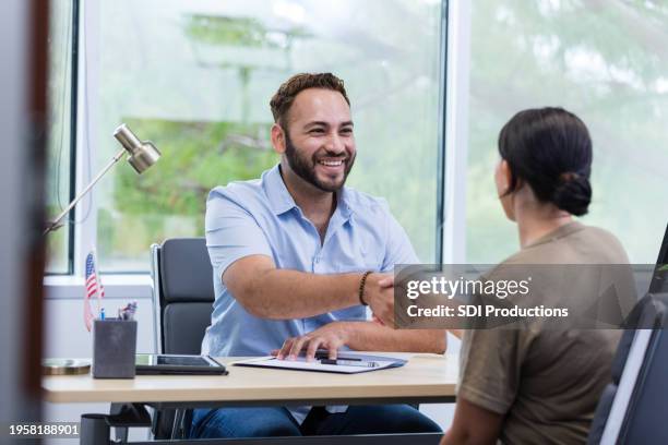 male financial planner shakes hands with unrecognizable female soldier - credit union stock pictures, royalty-free photos & images
