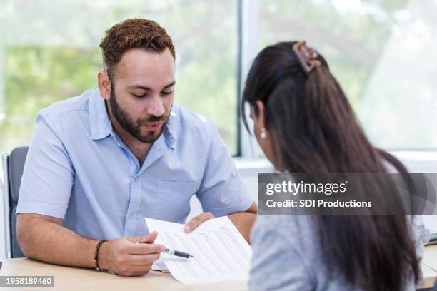 male banker patiently explains interest rates to unrecognizable woman - one on one stock pictures, royalty-free photos & images