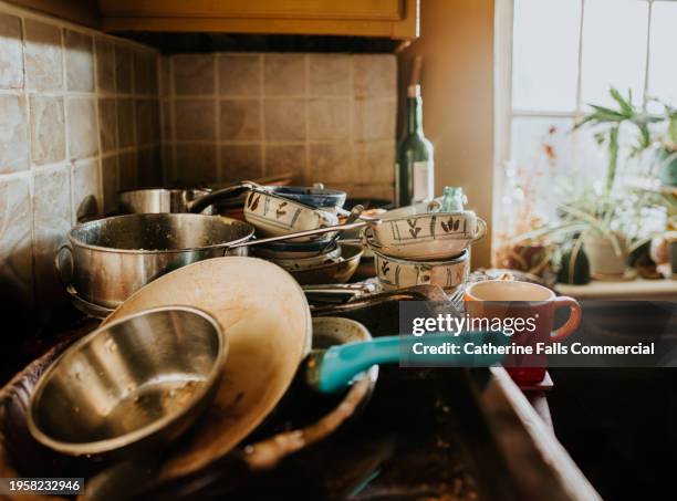 a pile of dirty dishes sit on a countertop in a kitchen - scourer stock pictures, royalty-free photos & images