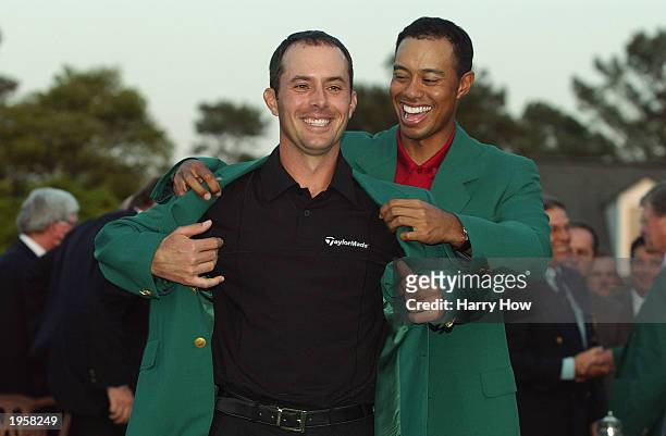 Mike Weir of Canada is presented with the green jacket by Tiger Woods of the USA after winning the play off after the final round of the 2003 Masters...