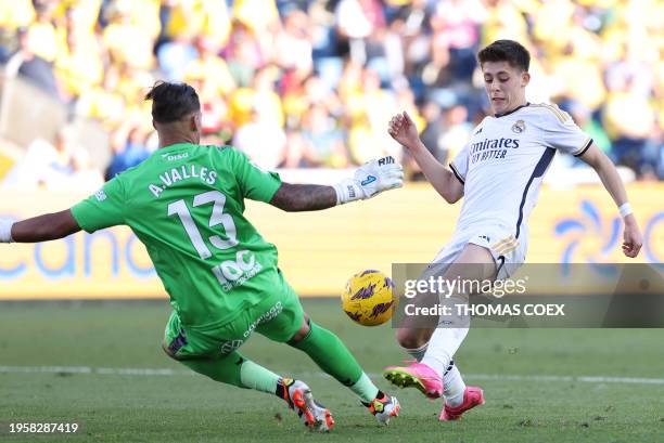 Real Madrid's Turkish midfielder Arda Guler fights for the ball with Las Palmas' Spanish goalkeeper Alvaro Valles during the Spanish league football...