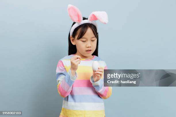 young girl celebrating easter against plain background - easter egg isolated stock pictures, royalty-free photos & images