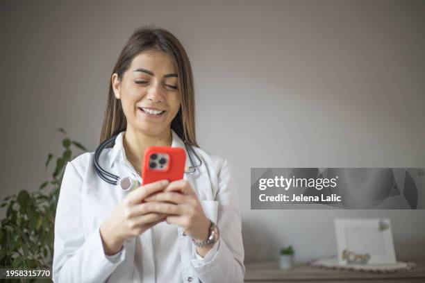 female doctor using smart phone - doctor text messaging stock pictures, royalty-free photos & images