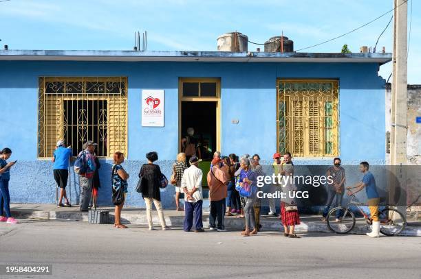 Santa Clara, Cuba, Cuban people lining up in a Catholic humanitarian institution in Maceo Street.