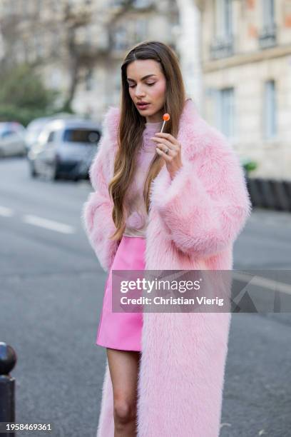 Mara Lafontan with a lollipop wears pink mini skirt, pink faux fur coat, blouse, heels outside Viktor&Rolf during the Haute Couture Spring/Summer...